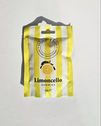 A package of Limoncello Gummies, featuring a yellow and white striped design with a lemon graphic, shown on a light gray background.
