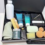 Assorted beauty and grooming products in a black box on a white surface.