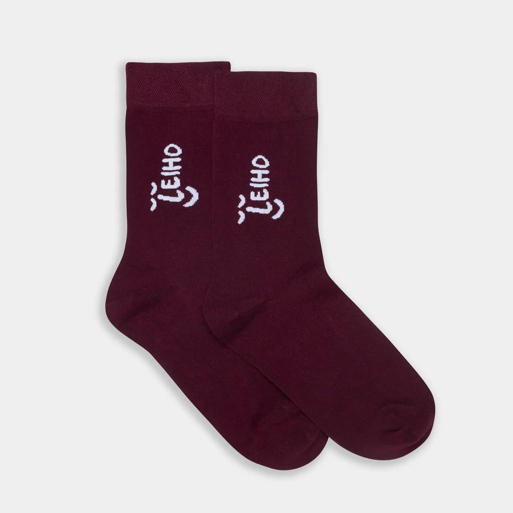 Pair of maroon socks with white text on a light gray background