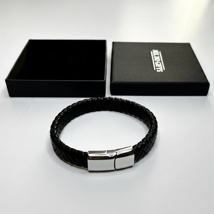Black braided bracelet with a silver clasp on a white background, featuring a branded box.