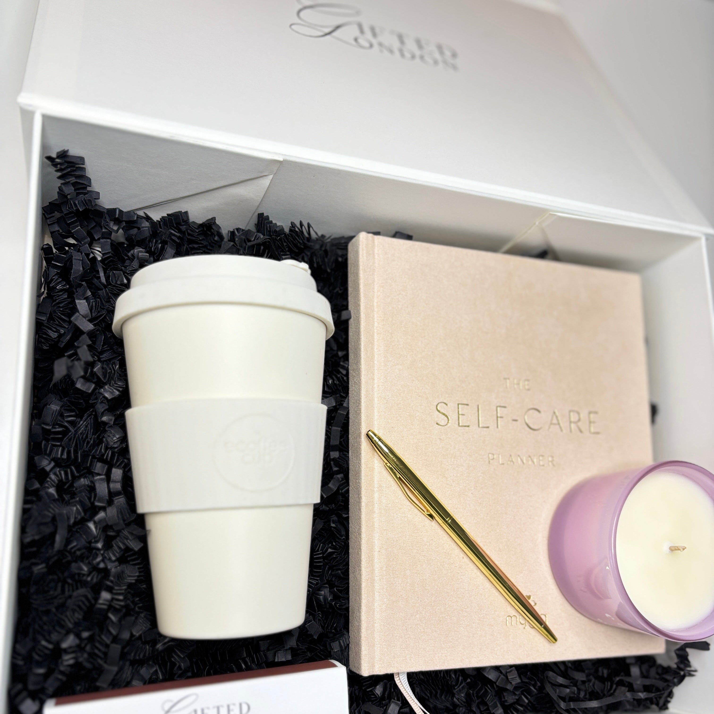 Gift set with a white cup, notebook, pen, and candle in a box labeled 'Gifted London'.